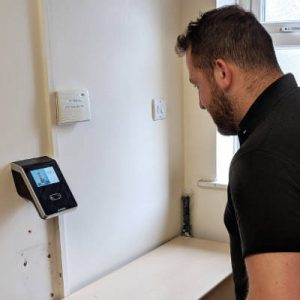 non-contact face recognition reader installed on the wall next to the site entrance